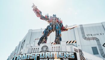 A giant robot statue stands atop a building, with a sign reading 